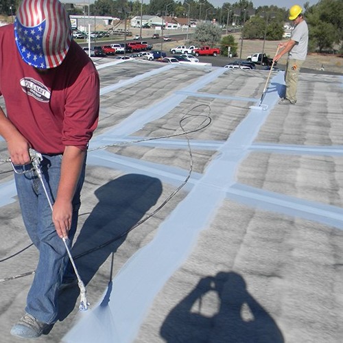 Contractor Applies Roof Restoration Coating.